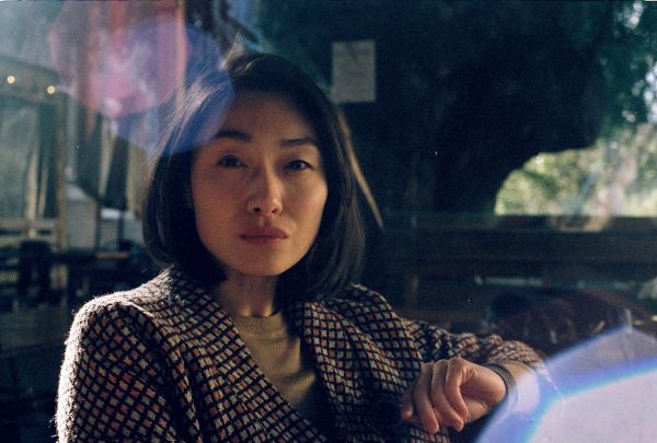 Woman posing at camera with light flares in background.