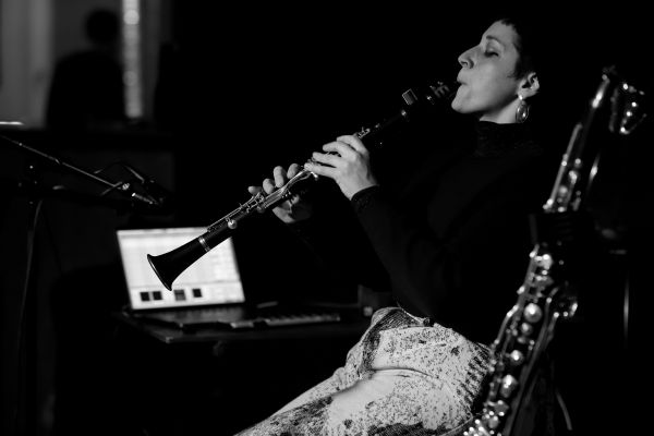 Black and white image of woman performing on stage with clarinet.