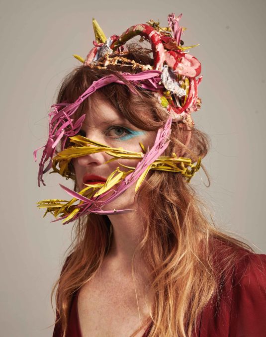Portrait of woman wearing colourful head piece.