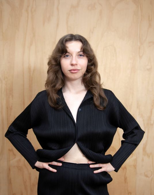 Woman posing in front of camera.