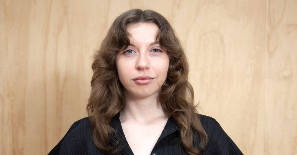Woman posing in front of camera.