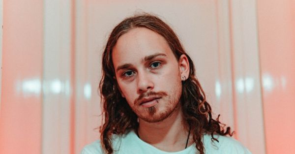 Headshot of long-haired artist facing at camera