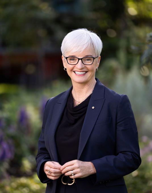 Emma Johnston in navy suit smiling at camera.