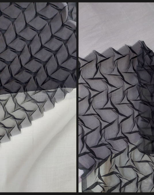 Image of two corner pieces of pleated black see-through silk on a white background